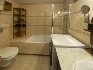 a bathroom with a tub and a toilet and a sink at BEACH FRONT GRANILLO - ocean view, garden, bright and comfortable, Wi-Fi in Costa Calma +11 photos