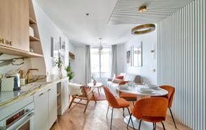 eine Küche und ein Wohnzimmer mit einem Tisch und Stühlen in der Unterkunft Sompteux appartement proche de L'Opéra in Paris