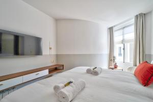 ein Schlafzimmer mit einem großen weißen Bett mit Handtüchern darauf in der Unterkunft Sompteux appartement proche de L'Opéra in Paris