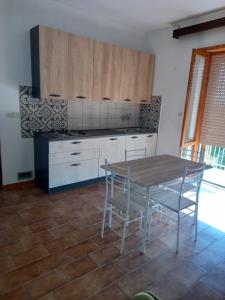 kuchnia ze stołem i krzesłami w pokoju w obiekcie G&M Holiday Home 2 w mieście Minturno