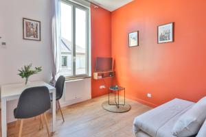 Habitación con paredes de color naranja, escritorio y cama en TERRA COTTA #Hypercentre #Charente #Parking, en Cognac