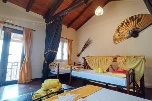 un soggiorno con 2 letti e una camera con sedie di ΟΝΕΙΡΟΠΑΓΙΔΑ-DREAM CATCHER a Áno Pavliána