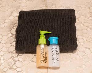 due bottiglie di profumatori accanto a un asciugamano nero di ΟΝΕΙΡΟΠΑΓΙΔΑ-DREAM CATCHER a Áno Pavliána