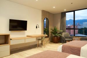a hotel room with a flat screen tv and a desk at Eutopiq Hotel in Medellín