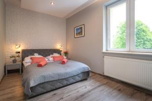 Un dormitorio con una cama con almohadas rojas. en Karkonosky Apartamenty- Salamandra, en Szklarska Poręba