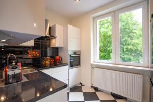 Una cocina con suelo a cuadros en blanco y negro. en Karkonosky Apartamenty- Salamandra, en Szklarska Poręba