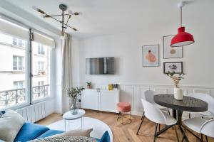 Biały salon ze stołem i krzesłami w obiekcie Sublime appartement au coeur de Paris w Paryżu