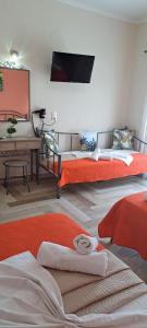 a room with two beds and a tv on the wall at Christodoulos Eleftheria House in Nea Vrasna