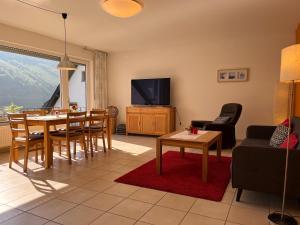 ein Wohnzimmer mit einem Tisch und einem TV in der Unterkunft Reis - feine Weine "Am Weingut" in Briedel