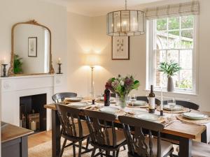 uma sala de jantar com uma mesa e cadeiras e uma lareira em Garden House at Woodhall Estate em Hertford