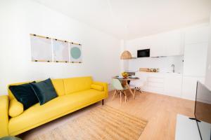 - un salon avec un canapé jaune et une table dans l'établissement Monsanto Hill House - NO. 565 1E, à Lisbonne