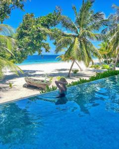 - une personne dans une piscine à côté d'une plage dans l'établissement Kiha Beach, à Dharavandhoo