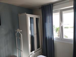 a bedroom with a white cabinet and a window at Punta Carnero Hostal singular in Algeciras