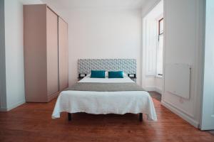 una camera da letto con un grande letto con cuscini blu di Harbour49 - AVEIRO FLATS & SUITES ad Aveiro
