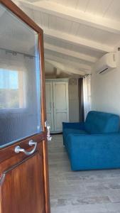 un soggiorno con divano blu e finestra di Stella Marina a Olbia