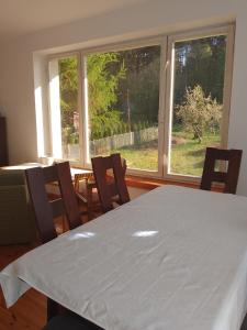 jadalnia ze stołem i krzesłami oraz oknem w obiekcie Nad jeziorem Korzybie w mieście Korzybie
