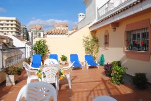 a patio with chairs and tables on a balcony at Hostal Italia in Fuengirola
