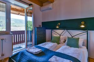 a bedroom with a bed and a large window at Pitypang Vendégház in Felsőtárkány +83 photos