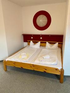 een bed met witte lakens en witte kussens erop bij Pension Sassnitz Atelierhaus in Sassnitz