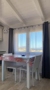 a dining room table with chairs and a window at Stella Marina in Olbia