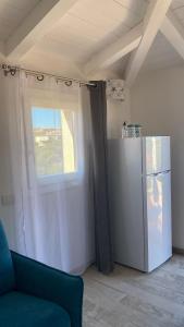 uma sala de estar com um frigorífico e uma janela em Stella Marina em Olbia