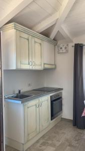 a kitchen with white cabinets and a stove at Stella Marina in Olbia