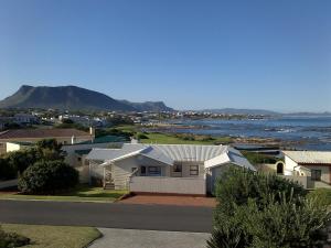a city with houses and the ocean and mountains at Pik 'n Wyntjie in Gansbaai