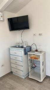 a tv on the wall above a white dresser at Stella Marina in Olbia