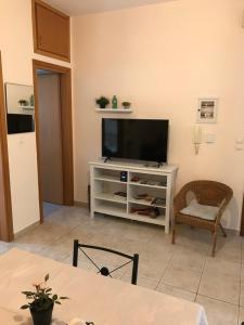 a living room with a television on a white entertainment center at Cozy Apartment Near City Center in Preveza