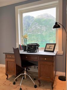 an office with a desk with a window and a desk at Nesje Gardstun in Oppstryn