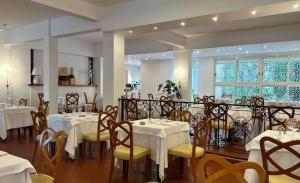 a restaurant with white tables and yellow chairs at Hotel Parco Delle Rose in Silvi Marina