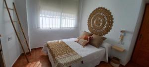 Schlafzimmer mit einem Bett und einem Wandspiegel in der Unterkunft CASA DEL PEZ Vivienda a pie de calle en Agua Amarga a 250 metros de la playa in Agua Amarga