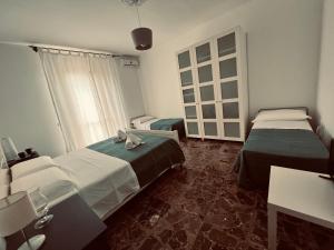 a hotel room with two beds and a window at Camelì Rooms & Holidays in Leporano