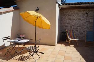 a yellow umbrella and a table and chairs on a patio at Chateau Le Livey in Saint-Pierre-dʼAurillac