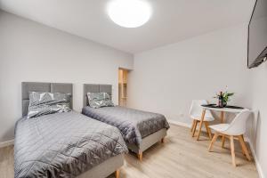 um quarto com 2 camas, uma mesa e uma secretária em Central Platinum Apartments 20 em Rybnik