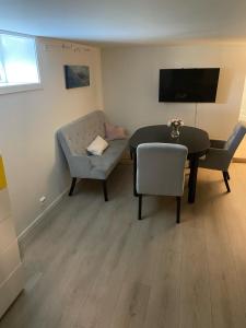 ein Wohnzimmer mit einem Sofa, einem Tisch und Stühlen in der Unterkunft Modern appartment in classic house, close to beach and city center in Kristiansand