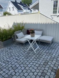 eine Terrasse mit 2 Stühlen und einem Tisch mit Kissen in der Unterkunft Modern appartment in classic house, close to beach and city center in Kristiansand