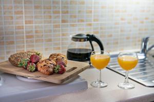 a counter with two glasses of orange juice and bread at Stella in the Village - Junior Studio Sea View in Plakias