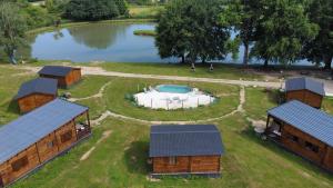 an aerial view of a farm with a pond and buildings at Chalet 35m2 Domaine du vieux chêne in Bergerac