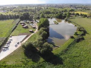 an aerial view of a lake with cars parked next to it at Chalet 35m2 Domaine du vieux chêne in Bergerac