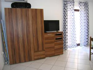 duże drewniane centrum rozrywki z telewizorem w obiekcie Apartments Murgic w Krku