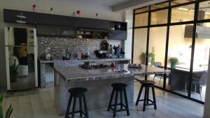a kitchen with a counter and two bar stools at Casa amazilia in Leticia