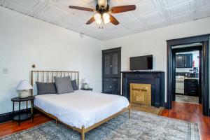 ノックスビルにあるHistoric Loft 5 minutes to downtownのベッドルーム1室(ベッド1台、天井ファン、暖炉付)