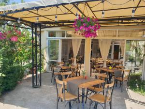 un restaurante con mesas, sillas y flores en Hotel Feniks en Lozenets