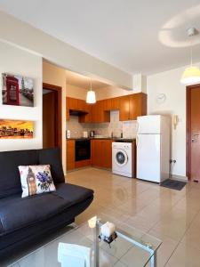a living room with a black couch and a white refrigerator at Albert's apartment Centre 601 in Larnaca