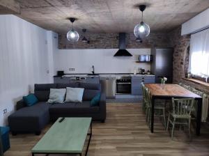 a living room with a couch and a table and a kitchen at La Cartería de Trabanca in Trabanca