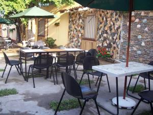eine Gruppe von Tischen und Stühlen mit Sonnenschirmen in der Unterkunft El Patio de Don Moncho in Nueva San Salvador
