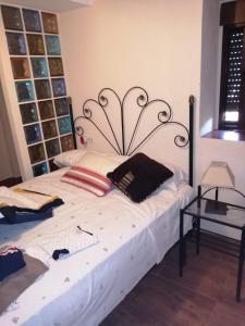 um quarto com uma grande cama branca e uma cabeceira preta em las palomas em Tózar