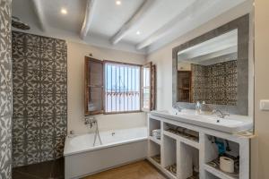 a bathroom with a tub and a sink and a mirror at Town house with roof terrace and plunge pool in Alcaucín +26 photos