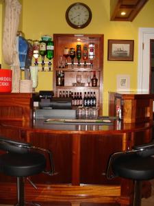a bar with chairs and a clock on the wall at Seaview Guesthouse in Rostrevor